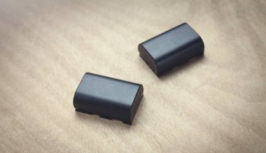 Ahşap arka planda kamera pili.