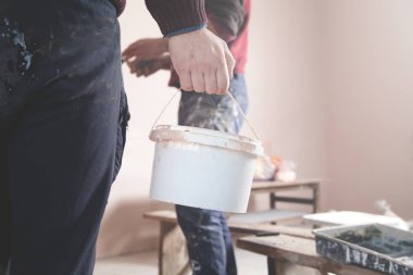 Adam evde çalışıyor. Kova boyalı bir işçi. Yenileme