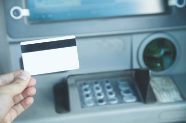 Kredi kartı olan bir adamın eli. ATM 'de. Parayı çek.