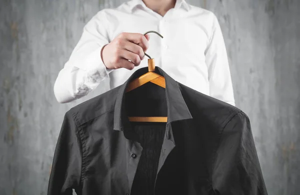 黒シャツのハンガーを持つビジネスマン — ストック写真