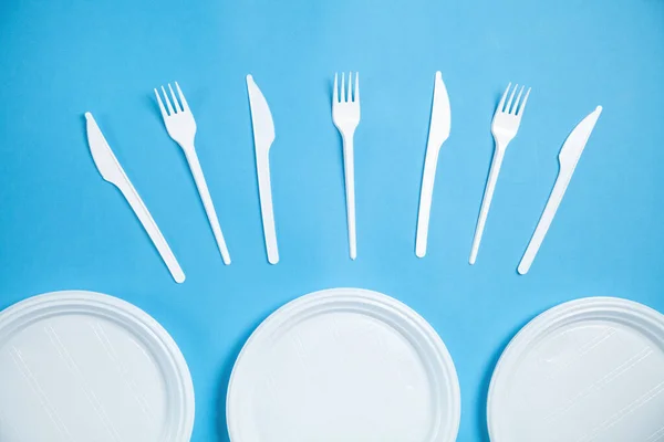 蓝色背景的白色塑料板 叉和刀具 — 图库照片