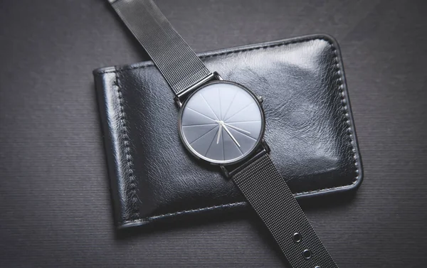 ブラックの背景にブラックの腕時計と財布 — ストック写真