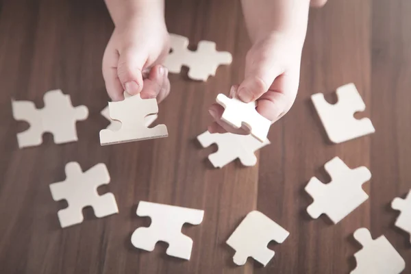 Kind Spielt Puzzle Auf Holztisch — Stockfoto