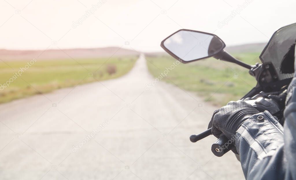 Motorcycle driver riding alone on asphalt motorway.