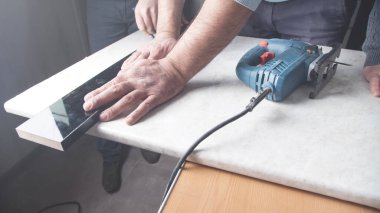 Elektrikli testereyle mutfak tezgahını kesen adam..
