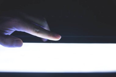 Erkek eli gece ekranda dokunuyor..