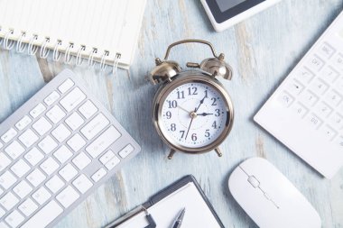 Masasında iş eşyası olan çalar saat.