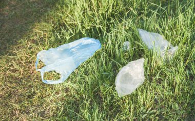 Parktaki çimlerin üzerinde plastik torbalar.