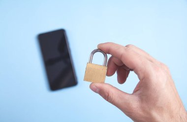 Erkek el asma kilidi tutuyor. Akıllı telefon güvenliği