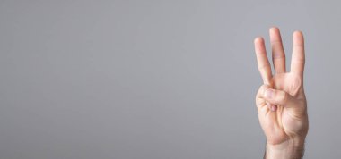 Erkek el üç parmak gösteriyor..