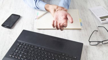 Kafkas işadamı ofiste el ağrısından muzdarip. 