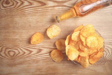 Tahta masada patates cipsi ve şişe bira..