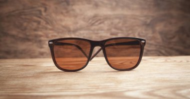 Ahşap arka planda kahverengi güneş gözlükleri.