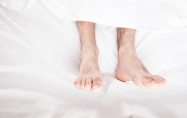 Sabahları yatakta erkek ayakları.