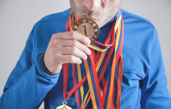 Caucasian sportsman kissing his medal. Winner