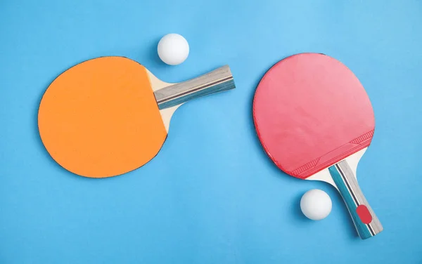 テーブルテニスラケットと青い背景に白いプラスチックボール — ストック写真