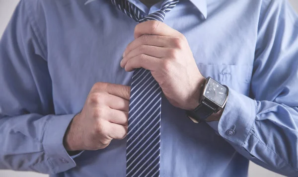 Businessman fixing his tie. Fashion, Lifestyle