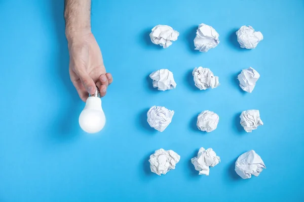 Hand Hält Glühbirne Zerknüllte Papiere Blauen Hintergrund Idee — Stockfoto