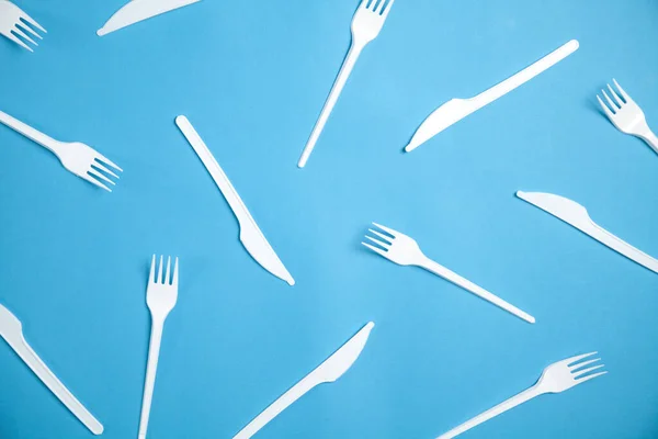 Plastic fork and knifes on the blue background.