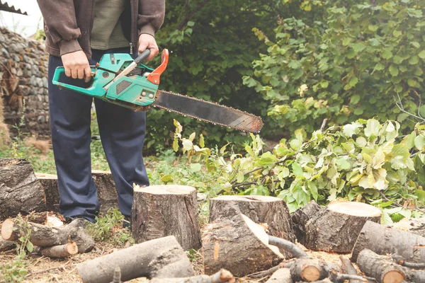 Man cutting wood with a chainsaw.