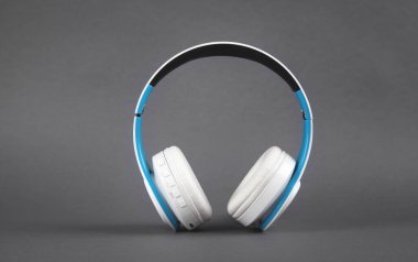 Koyu gri arka planda beyaz kablosuz kulaklık..