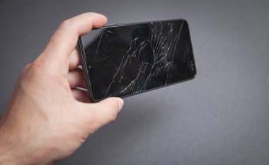 Elinde siyah bozuk akıllı telefon tutan adam. Kırık Ekran