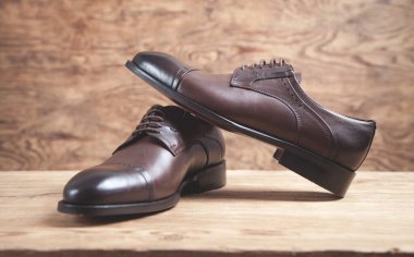 Ahşap arka planda kahverengi ayakkabılar..