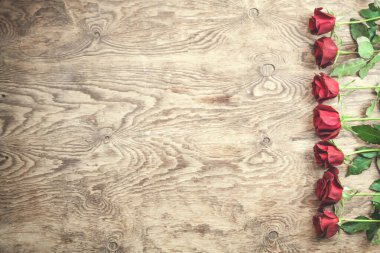 Ahşap arka planda kırmızı güller.