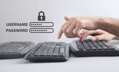 Erkek eller bilgisayar klavyesinde yazı yazıyor. Asma kilitli kullanıcı adı ve parola