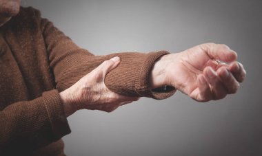 Dirsek ağrısı çeken yaşlı bir kadın..