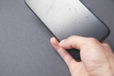 Elinde siyah bozuk akıllı telefon tutan adam. Kırık Ekran
