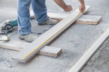 Tiler doğal fayansları ölçer ve keser..