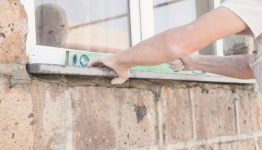 İşçi taş kurarken seviye kullanıyor.