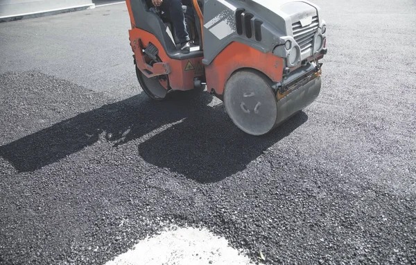 Asphalt roller stacking and pressing hot asphalt.