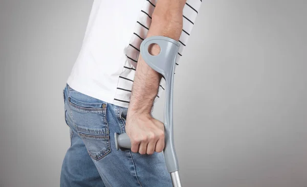 Caucasian Man Crutches Grey Background — Stock Photo, Image