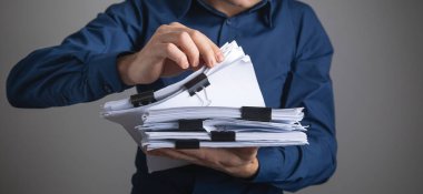 Kafkasyalı işadamı bir yığın belge gösteriyor.