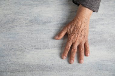 Yaşlı kadın eli masanın üstünde..