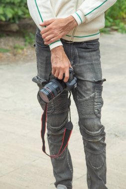 Elinde dijital bir fotoğraf makinesi olan fotoğrafçı doğada fotoğraf çekiyor..