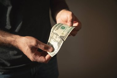 Beyaz adam yırtık dolar banknotu gösteriyor..