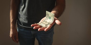 Beyaz adam yırtık dolar banknotu gösteriyor..