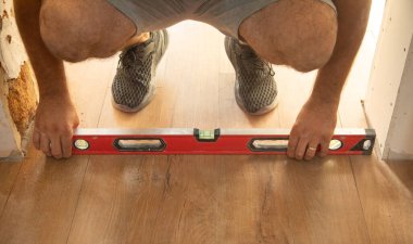  Katları kontrol etmek için ruh seviyesini kullanan işçiler.