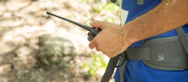 Ormanda telsizi olan beyaz bir adam..