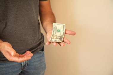 Beyaz adam yırtık dolar banknotu gösteriyor..