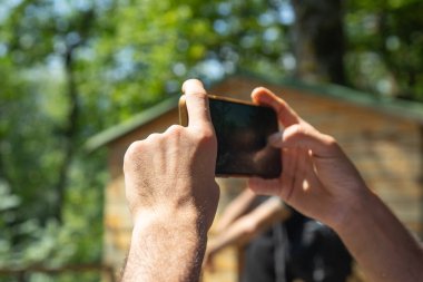 Açık havada cep telefonu kullanan beyaz bir insan..