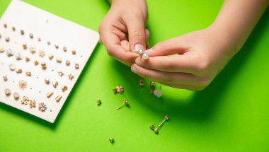 Genç kız elleri küpeleri gösteriyor..