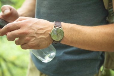 Doğada kol saati takan beyaz bir adam..