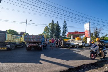 BAJAWA, İNDONEZYA - 15 Ekim 2025: Benzin istasyonunda yakıt almak için bekleyen uzun bir kamyon ve araç kuyruğu. Bu fotoğraf, bölgede devam eden ve yerel taşımacılıkta önemli kesintilere yol açan yakıt sıkıntılarını belgeliyor..