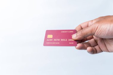 Temiz beyaz arka planda kırmızı, jenerik kredi kartı tutan bir adamın yakın plan fotoğrafı. Ödeme, finans, bankacılık, alışveriş ve çevrimiçi işlemler kavramı. Kopyalama alanı.