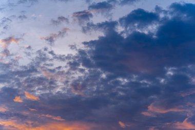 Gün batımında ya da gün doğumunda güzel bir gökyüzü. Turuncu ve pembe ışık bulutları mavi arkaplana karşı aydınlatır. Kusursuz soyut arkaplan.