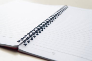 Sarmal bir dizüstü bilgisayarın yakın plan açılı bir görüntüsü. Temiz, beyaz, doldurulmuş sayfalar boş. Çalışma ya da notlar için mükemmel bir arkaplan.